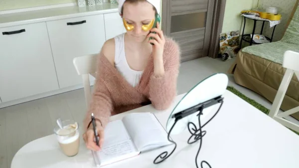 Aantrekkelijke zakenvrouw cosmetische gezichts plekken thuis, toe te passen op die zijn praten aan de telefoon — Stockfoto
