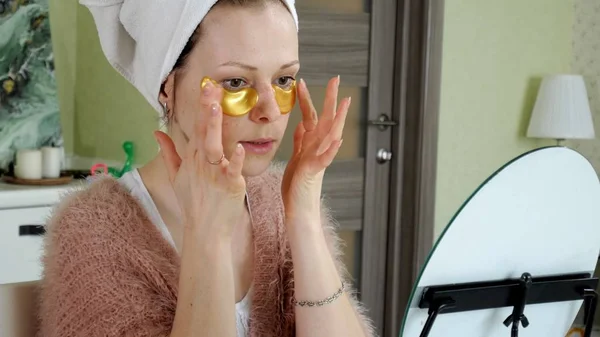 Attraktiv kvinna spplying kosmetiska ansikts patchar hemma — Stockfoto