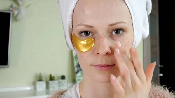 Aantrekkelijke vrouw spplying cosmetische gezichts patches thuis — Stockfoto