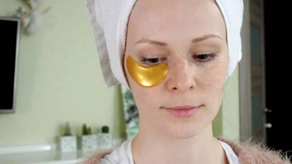 Aantrekkelijke vrouw spplying cosmetische gezichts patches thuis — Stockfoto