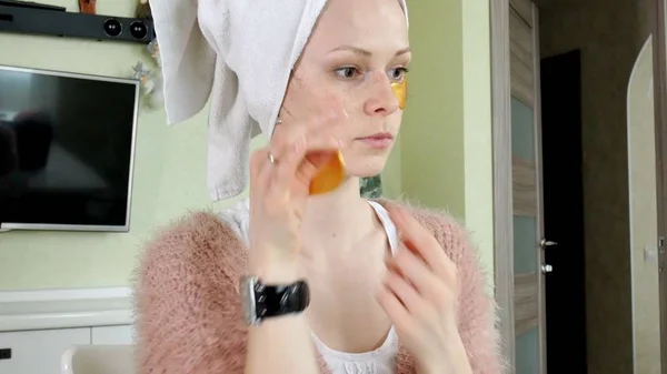 Çekici kadın spplying kozmetik yüz yamalar evde — Stok fotoğraf