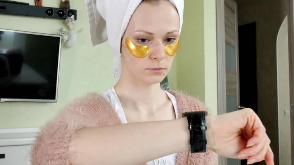 Attraente donna spionaggio cosmetici patch facciali a casa — Foto Stock