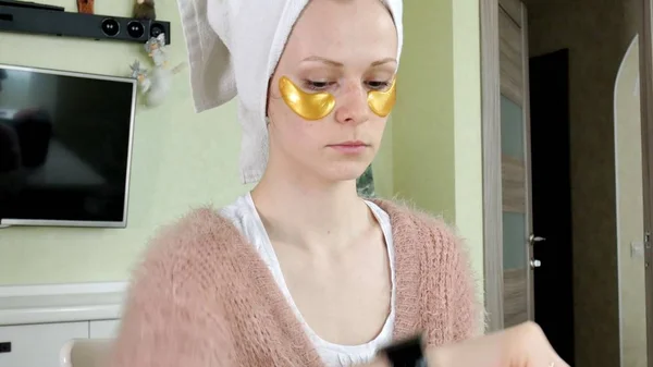 Attrayant femme spplying cosmétique visage patches à la maison — Photo