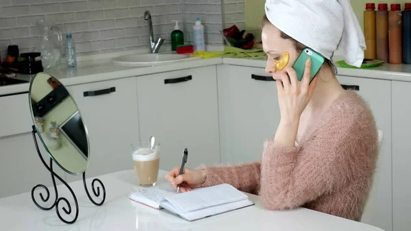 Mulher de negócios atraente aplicando manchas faciais cosméticos em casa, falando ao telefone — Fotografia de Stock