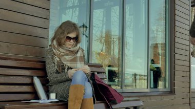 Genç kadın ve erkek bir termos şişe 4 k bir bankta oturan bir bahar parkta çay içme