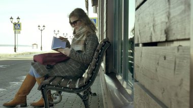 Park, onun defter elinde bankta oturan genç, güzel, güzel kadın. O bir ceket giyiyor. O notlar yapar ve çok romantik görünüyor.