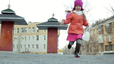 Küçük güzel kız su birikintileri üzerinde renkli balonlar ile yağmur sonra atlama