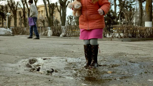 Niña hermosa saltando en charcos después de la lluvia — Foto de Stock