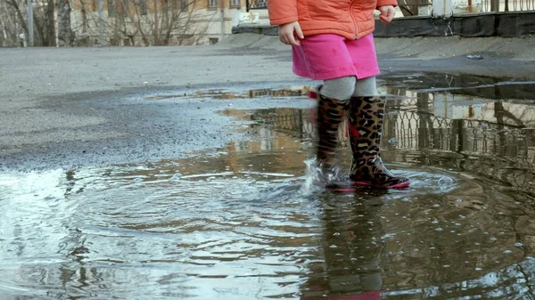 Όμορφο κοριτσάκι άλμα στις λακκούβες μετά τη βροχή — Φωτογραφία Αρχείου