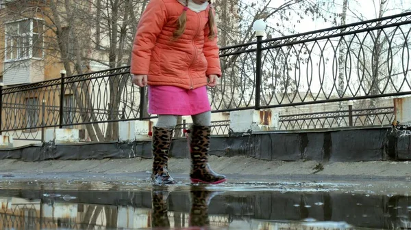 Little beautiful girl jumping on puddles after rain — Stock Photo, Image