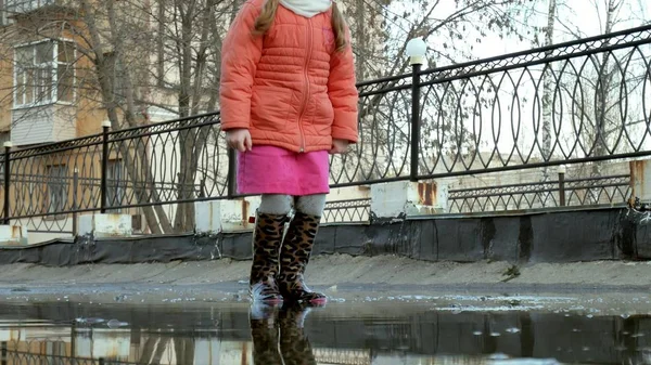 Όμορφο κοριτσάκι άλμα στις λακκούβες μετά τη βροχή — Φωτογραφία Αρχείου