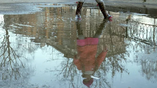 の雨の後水たまりにジャンプ美しい少女 — ストック写真