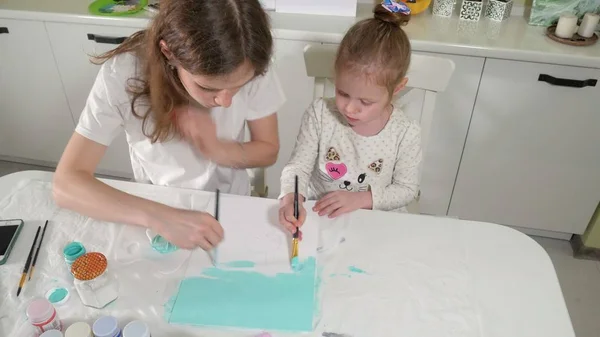 Madre e hijo pintan con pincel de colores. Los juegos con niños afectan el desarrollo de los niños pequeños . — Foto de Stock