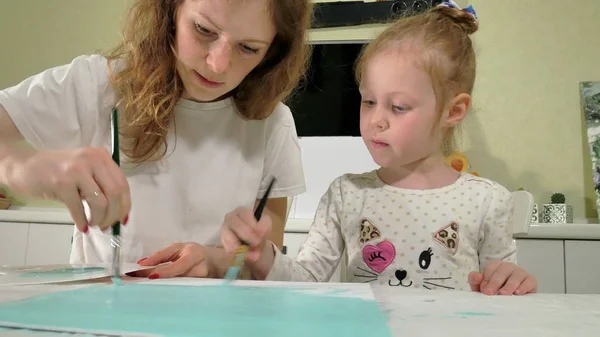 Peinture mère et enfant avec pinceau coloré. Jeux avec les enfants affectent le développement des jeunes enfants . — Photo