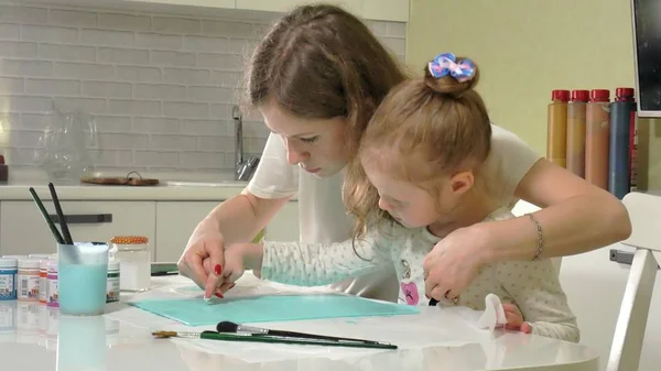 Madre e hijo pintan con dedos de colores. Los juegos con niños afectan el desarrollo de los niños pequeños . — Foto de Stock