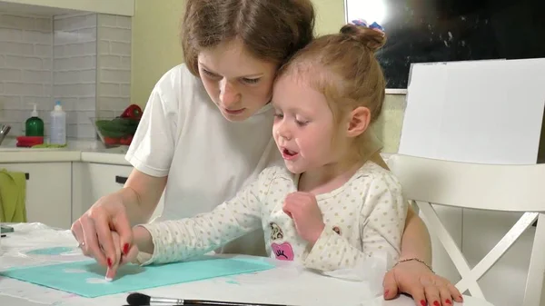 Madre e hijo pintan con pincel de colores. Los juegos con niños afectan el desarrollo de los niños pequeños . — Foto de Stock