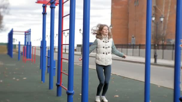 Jovem mulher fitness fazendo exercícios no ginásio em um parque ao ar livre — Vídeo de Stock