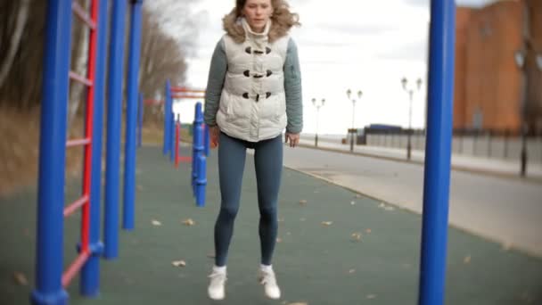 Joven mujer de fitness haciendo ejercicios en el gimnasio en un parque al aire libre — Vídeos de Stock