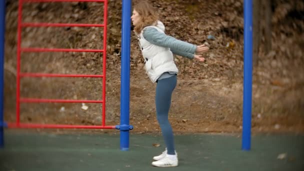 Jovem mulher fitness fazendo exercícios no ginásio em um parque ao ar livre — Vídeo de Stock