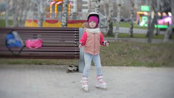 Mom and daughter ride on roller skates. Girl learning to roller skate, and falls. Mom teaches daughter to ride on rollers — Stock Video