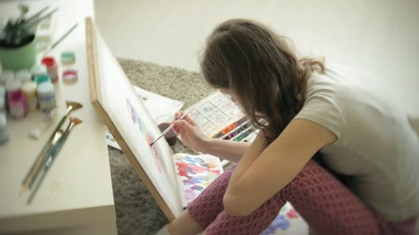 Jovem artista pintura mulher em casa sentado no chão pintura criativa — Vídeo de Stock