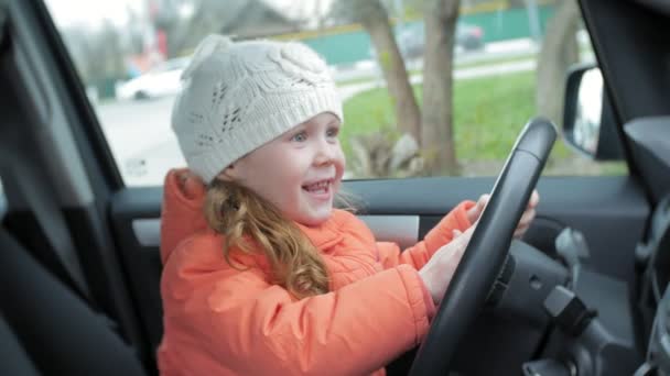 Linda niña detrás del volante del coche — Vídeos de Stock