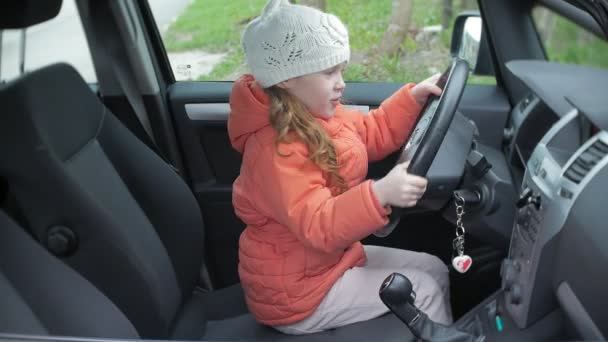 Cute little girl behind wheel of car — Stock Video