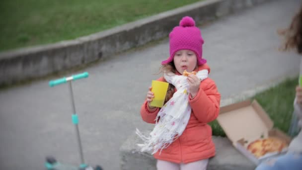 Sevimli küçük kız ve annesi pizza açık havada yemek. Beslenme, gıda ve yaşam tarzı — Stok video