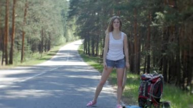 Yolda bir sırt çantası bir tablo ile bir yazıt güneye otostop kalan genç güzel kadın