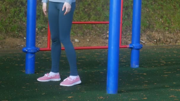 Junge Fitness-Frau macht Übungen auf der Turnhalle in einem Outdoor-Park — Stockvideo