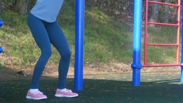 屋外公園のジムで演習を行って若いフィットネス女性 — ストック動画