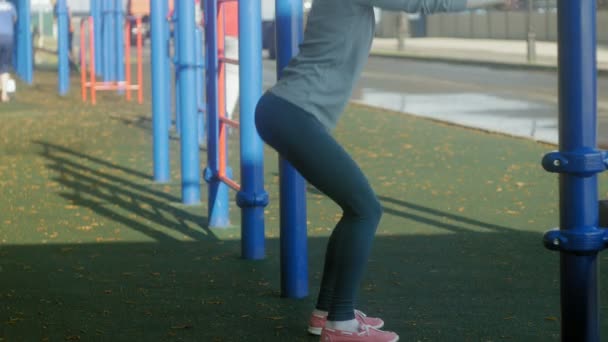 Νέοι γυμναστήριο γυναίκα κάνει ασκήσεις στο γυμναστήριο σε ένα υπαίθριο πάρκο — Αρχείο Βίντεο