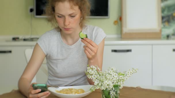 一个美丽的年轻女人吃鸡肉意大利面食在家庭厨房 — 图库视频影像