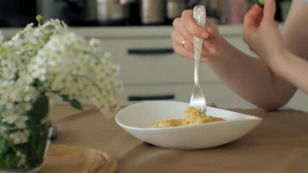 Een mooie jonge vrouw die het eten van kip Parmezaanse kaas pasta bij huis keuken — Stockvideo