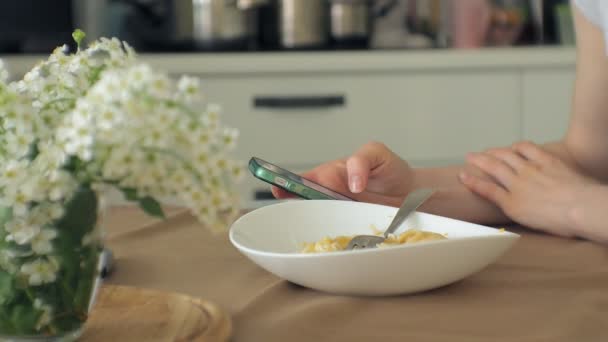 Krásná mladá žena jíst kuřecí parmezán těstoviny v domácí kuchyni — Stock video