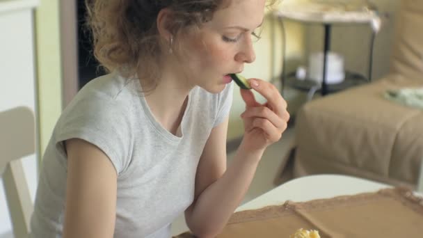 En vacker ung kvinna äta kyckling parmesan pasta på hem kök — Stockvideo