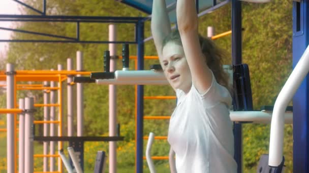 Junge Fitness-Frau macht Übungen auf der Turnhalle in einem Outdoor-Park — Stockvideo