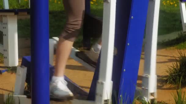 Молодая фитнес-женщина делает упражнения на тренажерном зале в открытом парке — стоковое видео