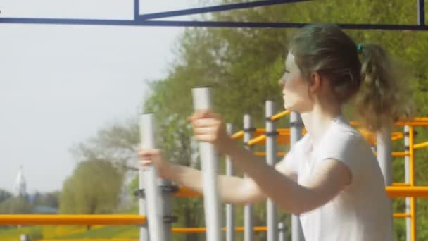 Young fitness woman doing exercises on the gym in an outdoor park — Stock Footage Young fitness woman doing exercises on the gym in an outdoor park Video Clip