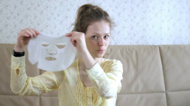 Genç kadının evde mutfak yüzüne maske temizlik ile yüz maskesi maskesi yapması