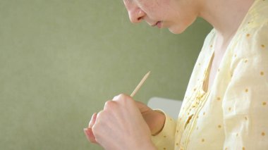 Kendiniz evde masada bir Manikür yapıyor kadın.