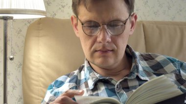 Evde yatak odasında bir kitap okuma yatakta yatan olgun adam