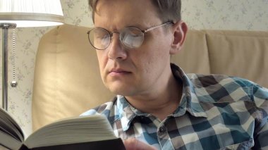 Evde yatak odasında bir kitap okuma yatakta yatan olgun adam