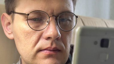 Online satın alma bir adam close-up bir telefon ve bir kredi kartı kullanan kanepede eve yaşam tarzı akıllı iş internet teknoloji banka bankacılık para tutan cep telefonu istemci closeup aygıt el alışveriş