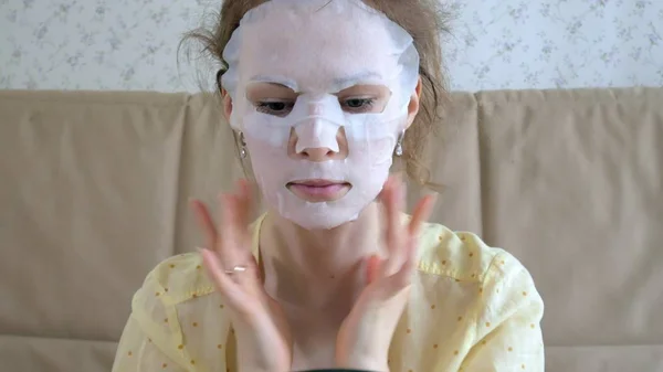 Mujer joven haciendo máscara facial con máscara de limpieza en la cara en la cocina en casa — Foto de Stock