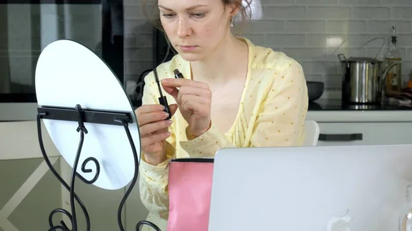 Jonge mooie vrouw, doet make-up voor een spiegel thuis. — Stockfoto