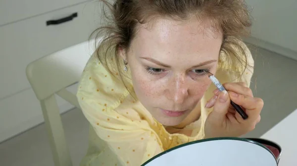 Junge schöne Frau schminkt sich zu Hause vor dem Spiegel. — Stockfoto