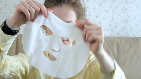 Genç kadının evde mutfak yüzüne maske temizlik ile yüz maskesi maskesi yapması — Stok fotoğraf