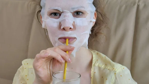 Mujer joven haciendo máscara facial con máscara de limpieza en la cara en la cocina en casa —  Fotos de Stock