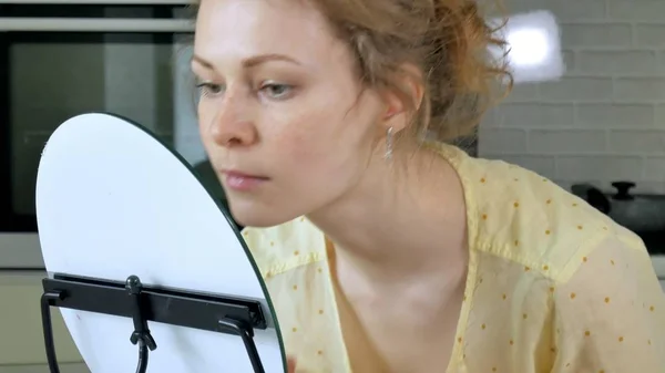 Jonge mooie vrouw, doet make-up voor een spiegel thuis. — Stockfoto